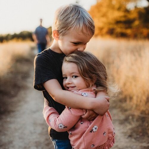 Young children hugging outdoors